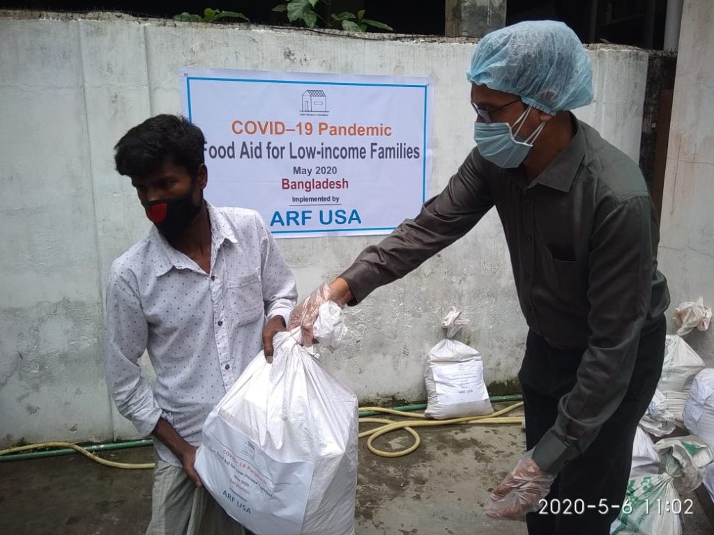 ARF USA volunteer distributing COVID-19 food aid to a family in Bangladesh, May 2020